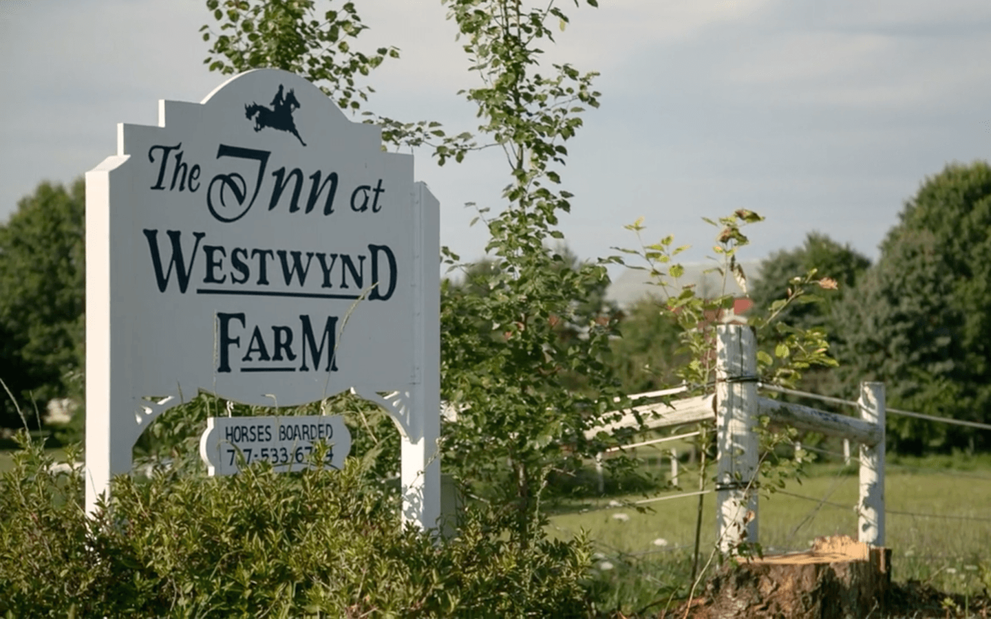 Sign for "The Inn at Westwynd Farm" surrounded by greenery.