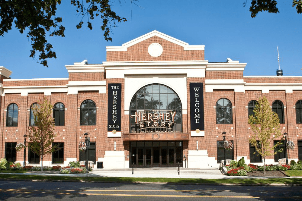 The exterior of the Hershey Story museum featuring brick architecture and large welcoming signs.