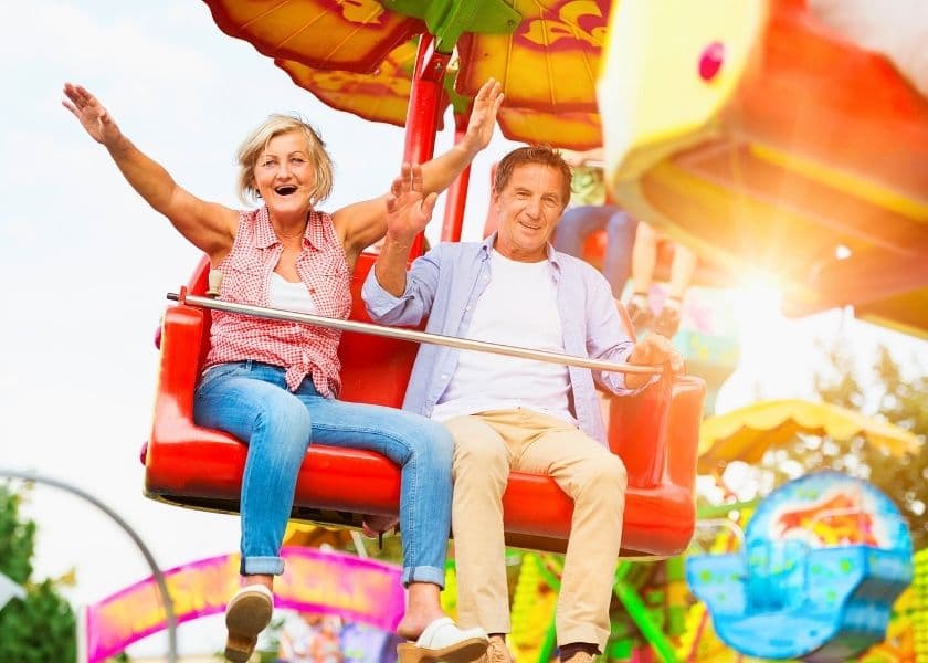 senior couple at amusement park laughing on ride senior couple at amusement park laughing on ride