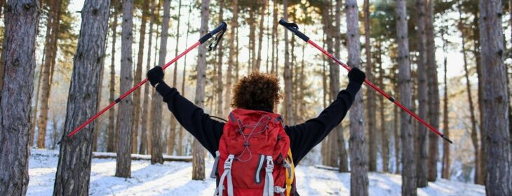 woman hiking through snowy forest