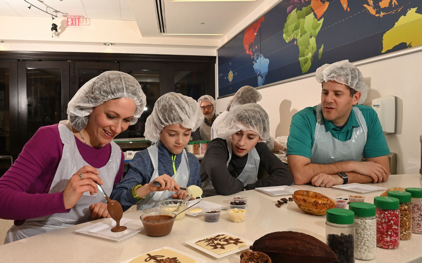 family creating their own chocolates in the chocolate lab at the hershey story museum