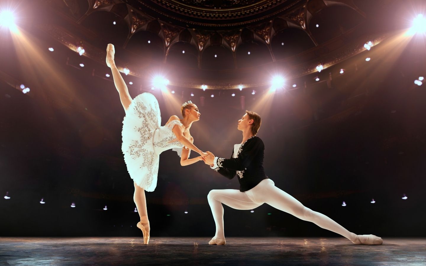 ballerinas performing pas de deux on theatre stage