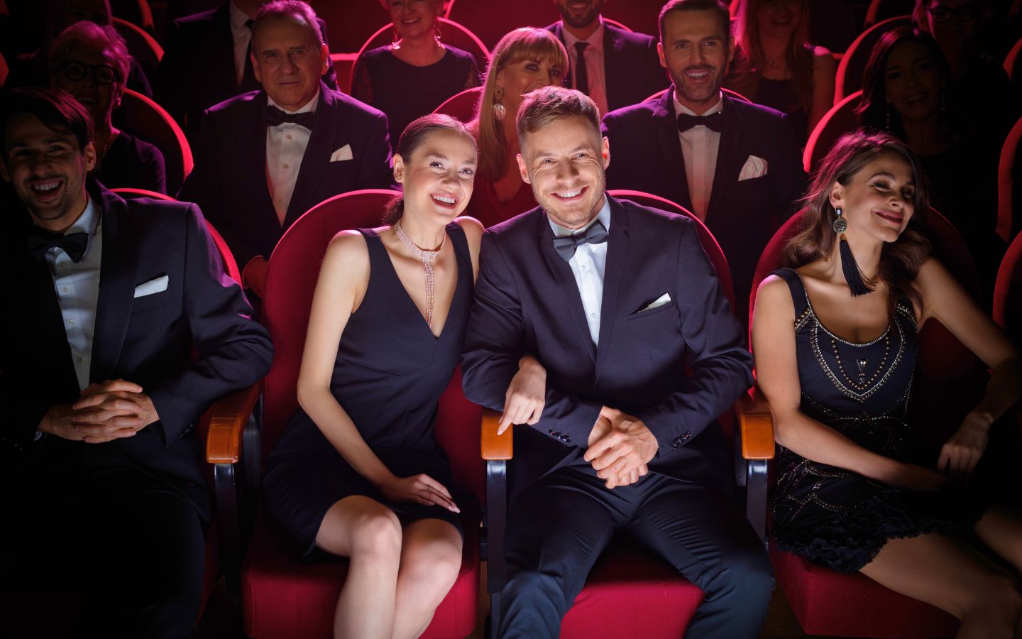 smiling couple watching theatrical performance in audience 